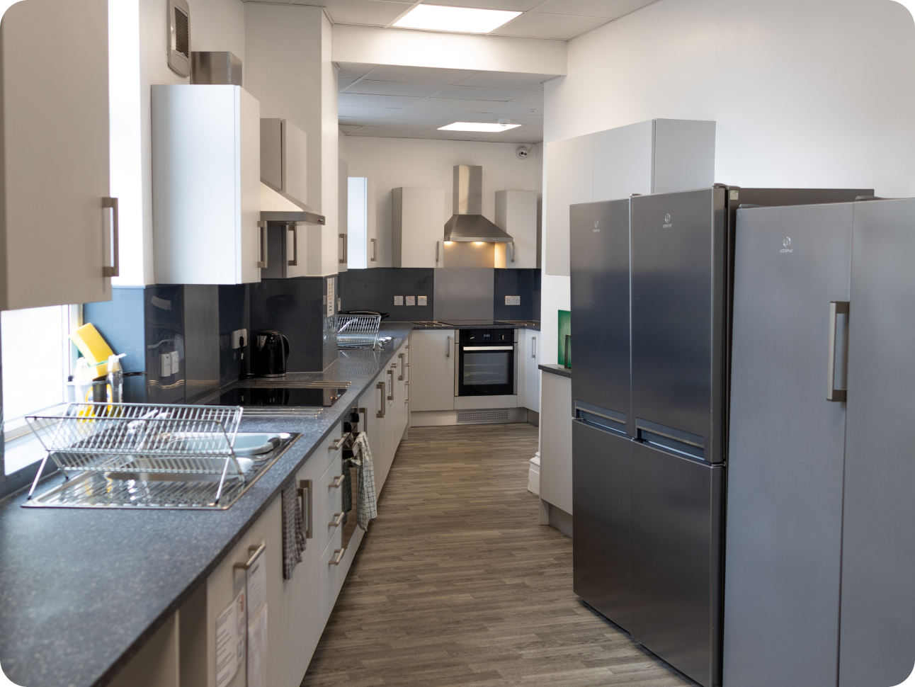 Silver and grey kitchen with appliances and wooden floor