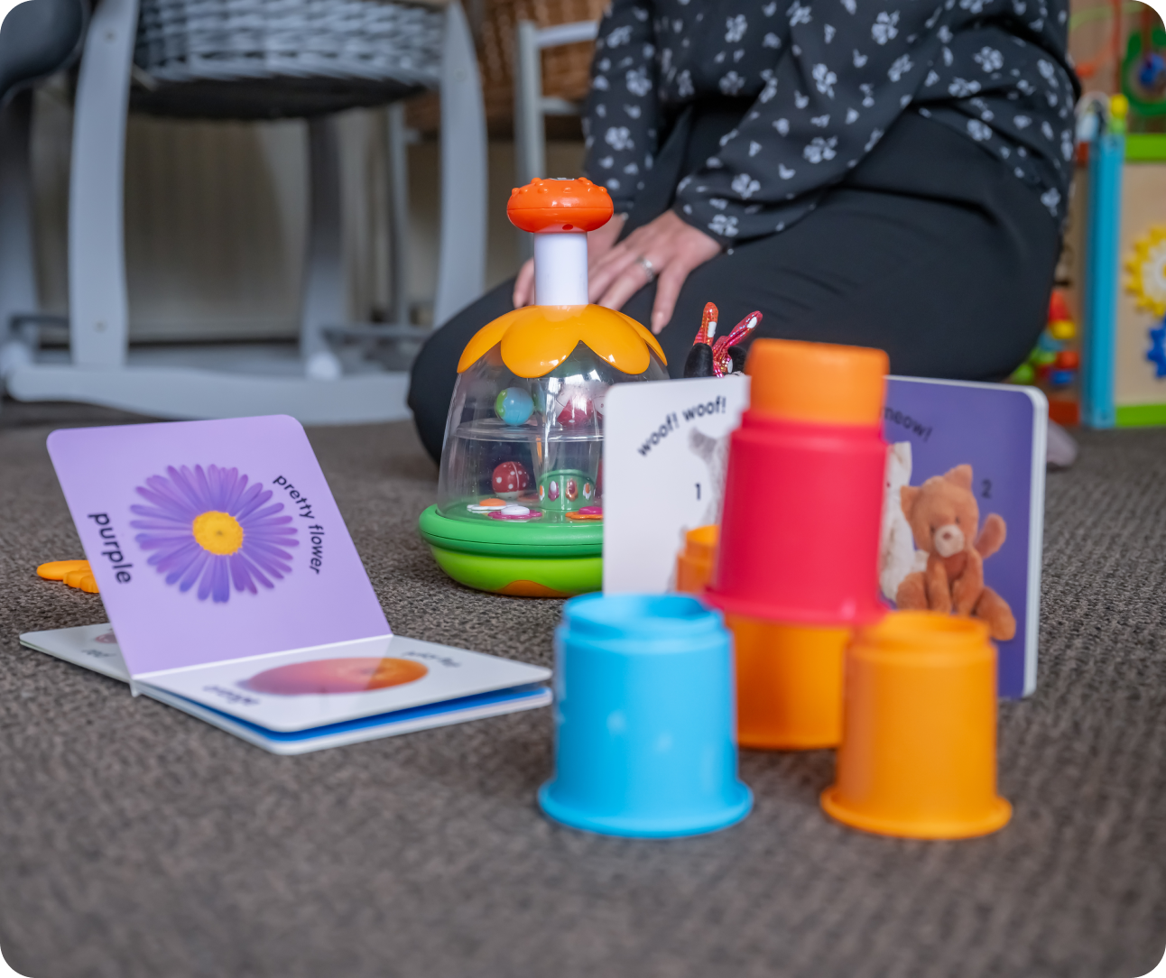 Young parents accommodation_ttoys on carpet including stacking cups and books